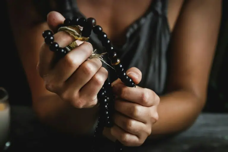 woman using prayer beads in her pranayama practice