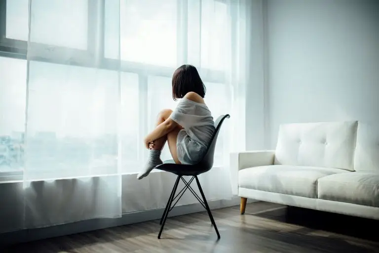 woman sitting on a chair looking out of the window