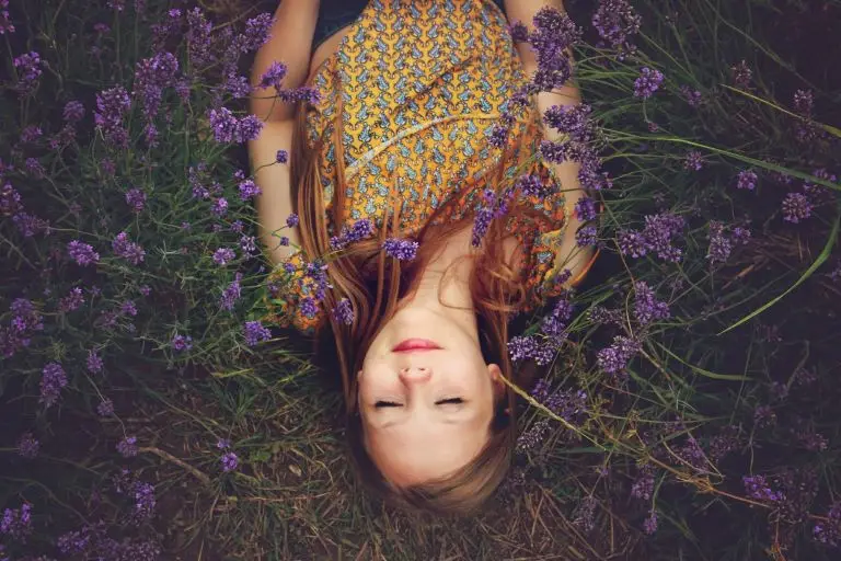 woman laying peacefully on a bed of wild flowers