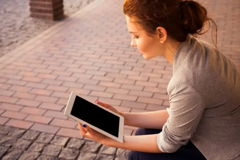 young woman researching meditation safety on a tablet device