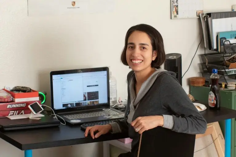 woman smiling in front of her computer after learning successful meditation practice tips