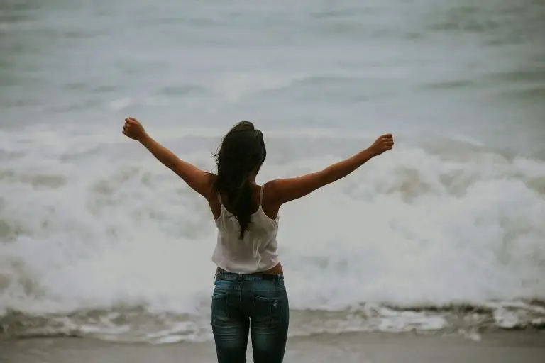 woman by the ocean using breathwork to release emotions